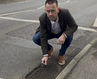 Cllr Colin Minto by blocked gully