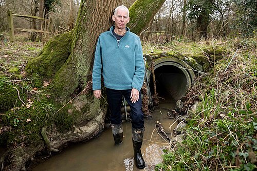 John Milne inspecting a local stream